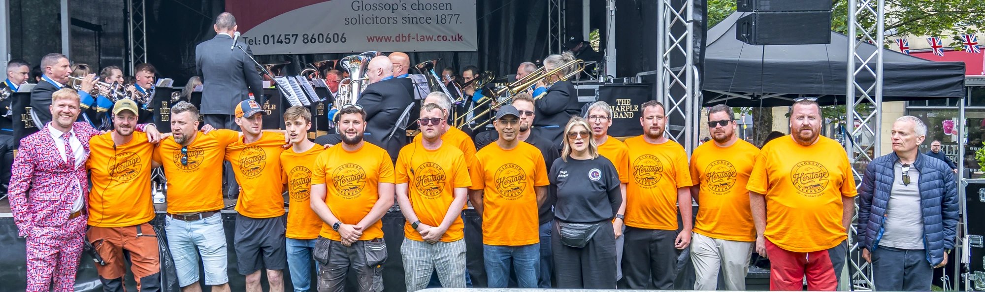 The Marple Band playing live on the Heritage Weekend main stage with Round Table volunteers in orange t-shirts in the foreground
